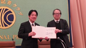 賴清德贈簽名 (右為毎日新聞論説室専門編集委員坂東賢治)
