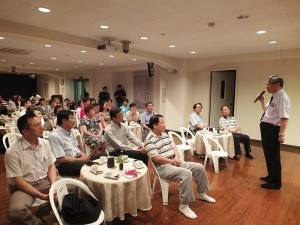 慈濟加拿大分會執行長何國慶和與會者分享參與慈濟活動的故事
