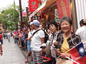 路旁的遊客也手持國旗，一同慶祝中華民國的生日