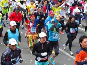穿著國旗裝和原住民莊跑者興奮地揮手起跑