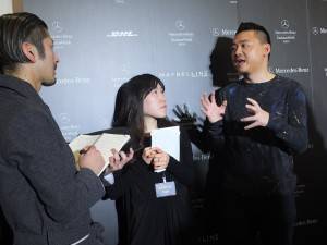 秀後古又文(右)接受日本媒體採訪,暢談他的時裝設計