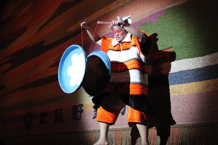 大きいコマを操ろうとするハチの格好をした団員 copy