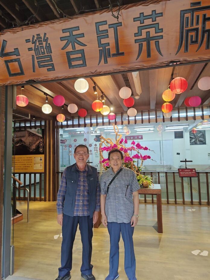 王坤連総経理は茶廠の正門前で歓迎してくれました 左 : 王坤連総経理、右 : 大田一博(王輝生)理事長紀念合影