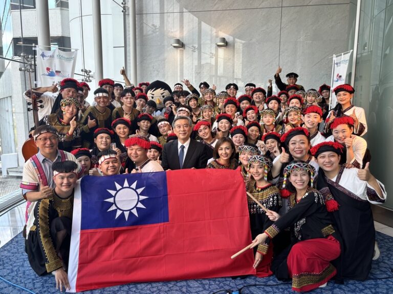 台灣合唱團赴日本參加東京國際合唱大賽，臨時遭到中國抗議要求撤下國旗，經過駐日代表處嚴正抗議並斡旋，最終包括五星旗在內，所有國旗都從會場撤下。駐日副代表周學佑（中）、立委邱議瑩（前排右4）以及尼布恩合唱團與國旗合影。(照片取自中央社)