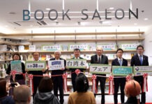 與會貴賓手持手拿板合影(右起自民黨青年局局長高見康裕眾議員、前局長平沼正二郎眾議員、日本台灣友好議員聯盟會長古屋圭司眾議員、駐日代表處李逸大使、紀伊國屋書店代表取締役會長高井昌史、日本台灣交流協會理事長谷崎泰明、SNET台灣代表理事、日本大學教授赤松美和子，臺灣文化中心提供)